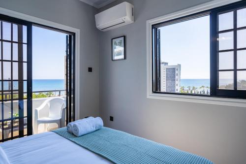 a bedroom with a bed with a view of the ocean at Peale's 2-Bedroom Apartment in Mackenzie in Larnaka