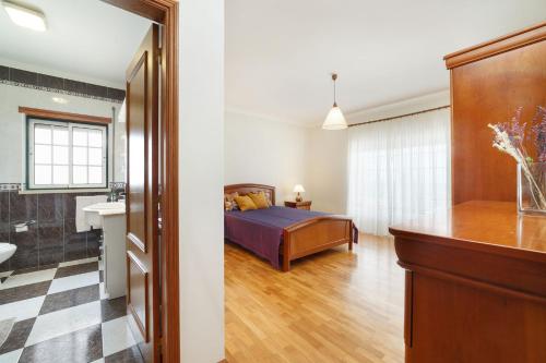 a bedroom with a bed and a bathroom at Casa do Monte Amarelo in Fátima