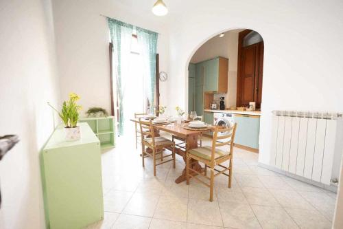 een keuken en eetkamer met een tafel en stoelen bij Alloggio in palazzina stile Liberty Fronte Mare in Nettuno