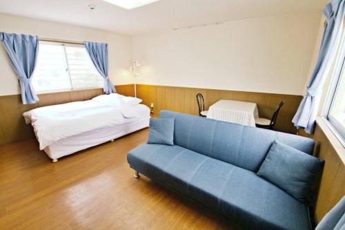 sala de estar con sofá y cama en ピースリー安里301, en Tomari