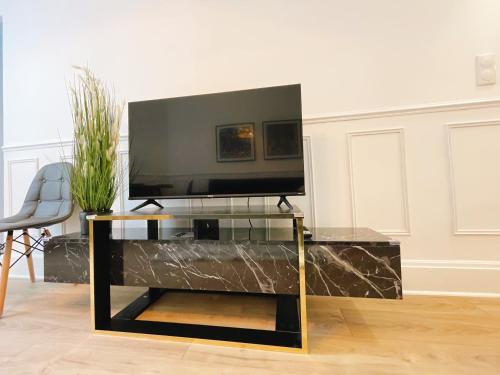 - un centre de divertissement noir avec une télévision à écran plat dans l'établissement Villa muguette - coeur de Vichy- 2éme étage, à Vichy