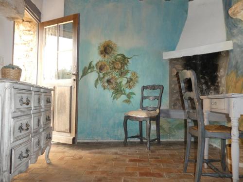 ein Zimmer mit einem Stuhl und einem Gemälde an der Wand in der Unterkunft Le Jas des aiguiers in Saint-Saturnin-dʼApt