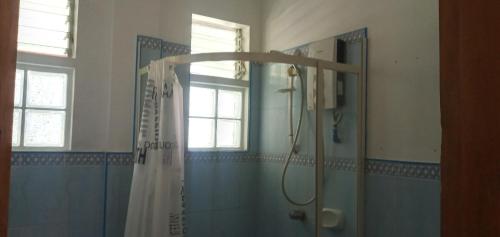 a bathroom with a shower with a shower curtain at Casa James Apartment, Rooms , Pool and Restaurant in Siquijor