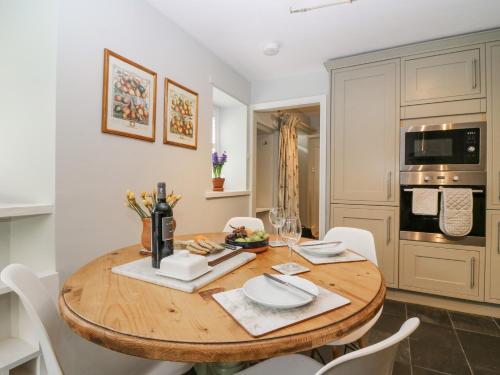 a dining room with a wooden table and white chairs at Dunira in Cupar