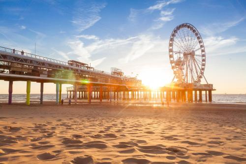 a beach with a pier and a ferris wheel at Bilderberg Europa Hotel Scheveningen in Scheveningen