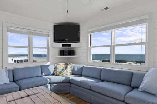 a living room with a blue couch and a flat screen tv at Suncatcher home in Atlantic Beach