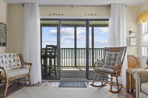 sala de estar con una puerta corredera de cristal que da a un balcón en Point Prospect Shores condo, en Pine Knoll Shores