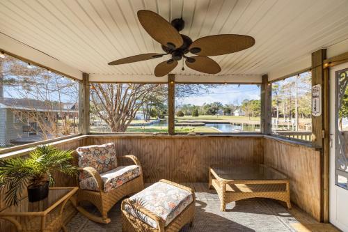 porche cubierto con ventilador de techo y sillas en Otter Banks Retreat home, en Harkers Island