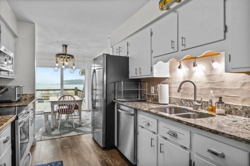 a kitchen with a stainless steel refrigerator and a table at Water's Edge Retreat home in Smyrna