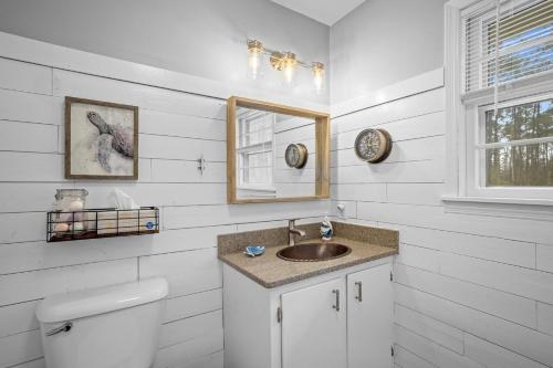 a bathroom with a sink and a mirror and a toilet at Water's Edge Retreat home in Smyrna