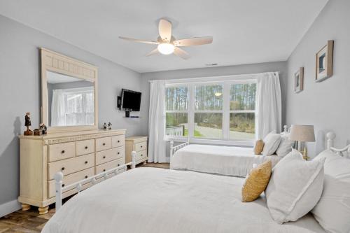 a bedroom with two beds and a ceiling fan at Water's Edge Retreat home in Smyrna