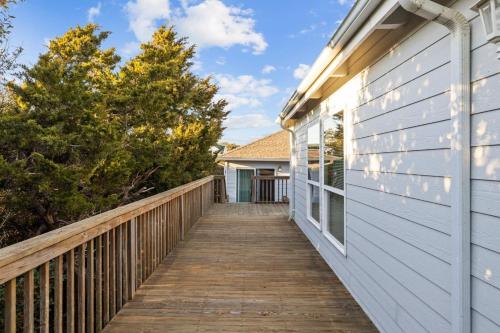 a wooden walkway leading to a house at Dogwood Treehouse home in Pine Knoll Shores