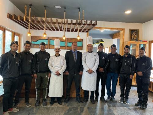 a group of chefs posing for a picture in a kitchen at Prakriti-The Retreat in Gangotri