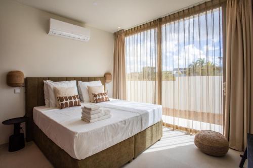 a bedroom with a large bed and a large window at Villa Wahoo in Jan Thiel