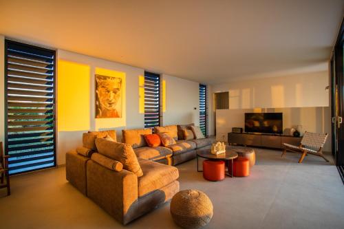 a living room with two couches and a tv at Villa Wahoo in Jan Thiel