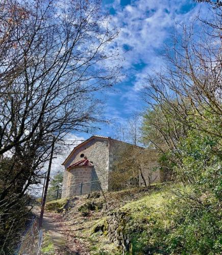 an old stone barn on a hill with trees at Chalet Perivoli in Perivólion