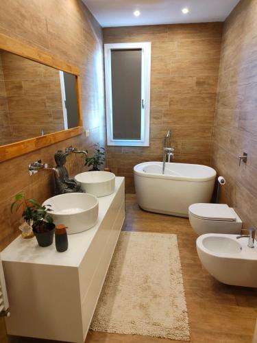 a bathroom with two sinks and a tub and two toilets at Suite12 in Marsala