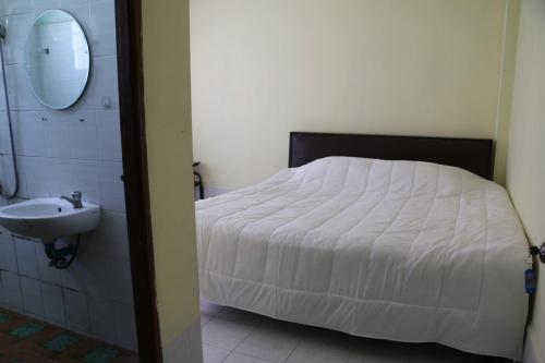 a bedroom with a white bed and a sink at Rainbow Hotel Vientiane in Vientiane