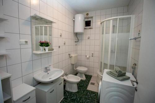 a bathroom with a sink and a toilet and a shower at Apartments by the sea Duce, Omis - 7576 in Duće