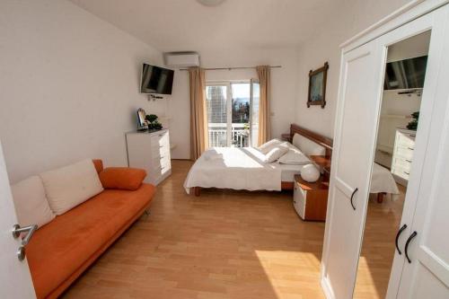 a bedroom with a bed and a couch in it at Apartments by the sea Duce, Omis - 7576 in Duće