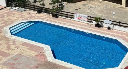 een groot blauw zwembad op een patio bij Casa Azzuro - Luxurious Modern Apartment Kapparis in Paralimni