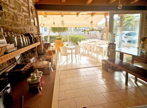 um restaurante com uma mesa e cadeiras num quarto em Alonia Hotel em Kalamaki