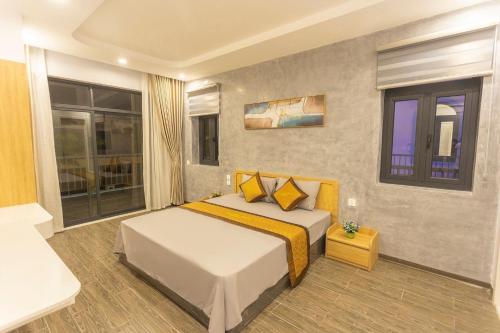 um quarto com uma cama com almofadas amarelas em Villa FLC Sầm Sơn BT VIP Phong Cách Địa Trung Hải em Sam Son