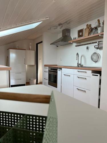 a kitchen with white cabinets and a stove top oven at Dachgeschosswohnung in Weiherhammer in Weiherhammer