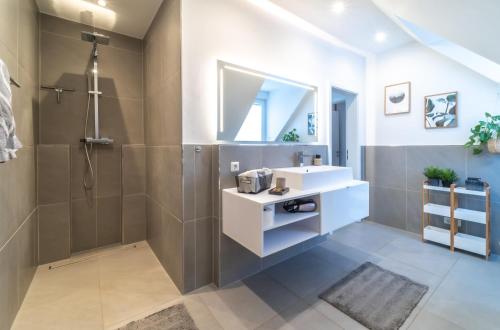 La salle de bains est pourvue d'un lavabo et d'une douche. dans l'établissement FEWO am Schwanenteich mit Dachterrasse - Innenstadt, à Emden