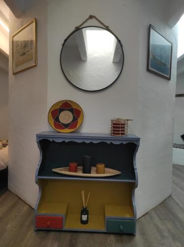 een spiegel aan een muur naast een plank bij Casa Sa Posidonia -POSIDONIA SURF & STAY- in Ciutadella