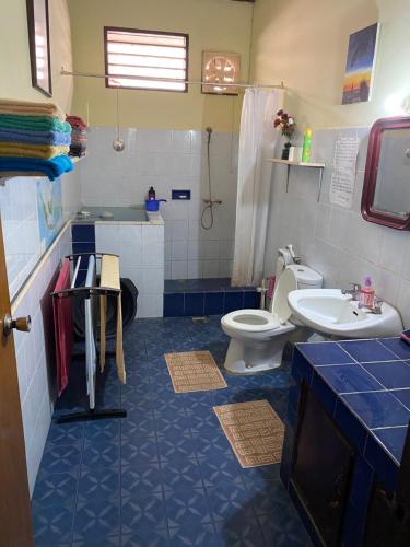 Homestay Galpera Papua في جايابورا: حمام ازرق وابيض مع مرحاض ومغسلة