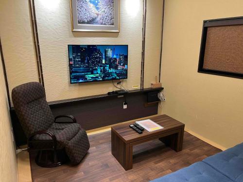 a room with a chair and a tv and a table at Japanese Modern House in Shinagawa in Tokyo