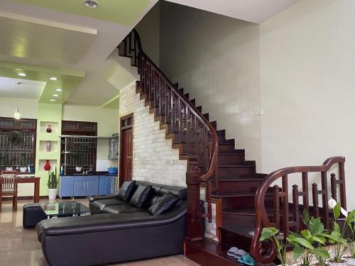 a living room with a couch and a staircase at Su Homestay in Cao Bằng