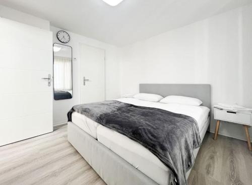 a white bedroom with a large bed and a mirror at Schickes Apartment in City Lage B7 in Karlsruhe