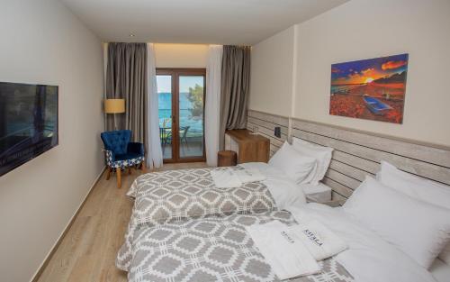 a hotel room with two beds and a television at Kavala Resort & Spa in Nea Karvali