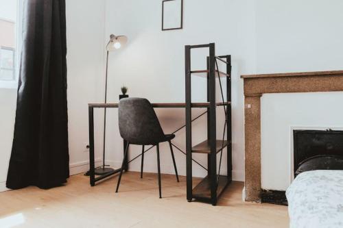a chair sitting in front of a desk next to a fireplace at NEPTUNE - Appartement Moderne & élégant in Saint-Étienne