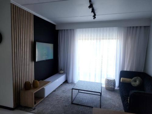 a living room with a couch and a large window at Manelo in Fourways in Fourways