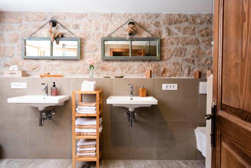 La salle de bains est pourvue de 2 lavabos et de 2 miroirs. dans l'établissement Villa Vita, à Trilj