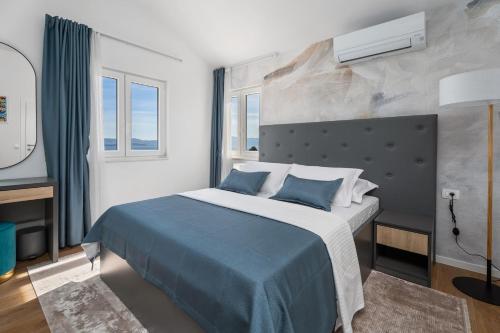 ein Schlafzimmer mit einem großen Bett mit einer blauen Decke in der Unterkunft Villa Ora with Heated pool, Whirlpool, 4 bedrooms in Grohote
