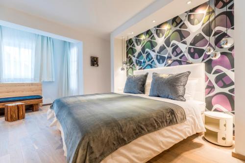 a bedroom with a large bed with a colorful wall at Hotel Flachauerhof in Flachau