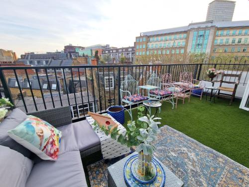 a balcony with a couch and a table with flowers at flat Covent Garden in London