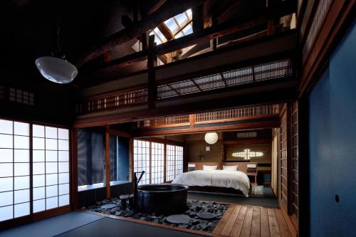 豐岡的住宿－城崎温泉 旅館 つばき乃 - Kinosaki Onsen Ryokan Tsubakino，一间卧室配有一张床和一个浴缸