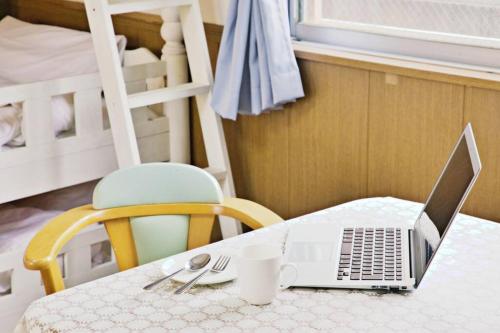 um computador portátil sentado numa mesa num quarto em ピースリー安里201 em Tomari