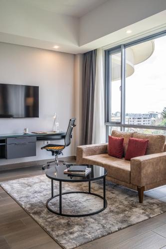 a living room with a couch and a table at Dusit Princess Hotel Residences Nairobi in Nairobi
