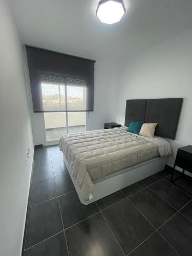 ein Schlafzimmer mit einem großen Bett und einem großen Fenster in der Unterkunft Apartamento Luli in Calpe