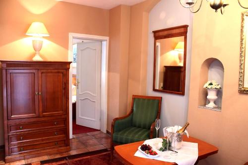 a room with a table and a chair and a mirror at Parkhotel Fischer in Wernigerode