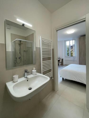 a bathroom with a sink and a bed and a mirror at Carissimi 4 in Milan