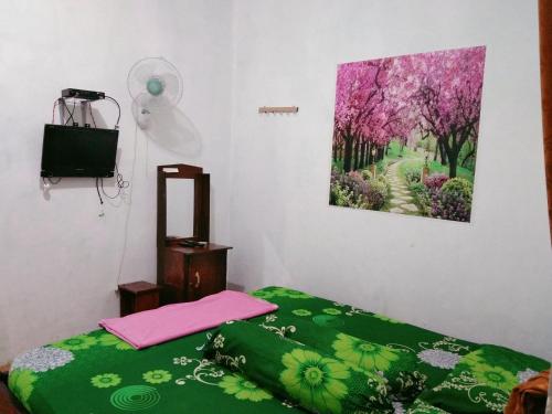 een slaapkamer met een bed en een schilderij aan de muur bij Homestay Nova Klayar in Kalak