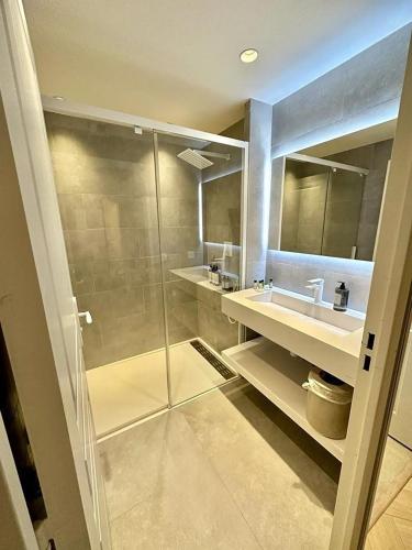 une salle de bain avec douche et lavabo dans l'établissement CAM0 - appartement 2 chambres en rez-de-terrasse, à Cannes
