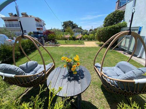 two chairs and a table with a vase of flowers at JASMINE STUDIOS POTOS in Potos